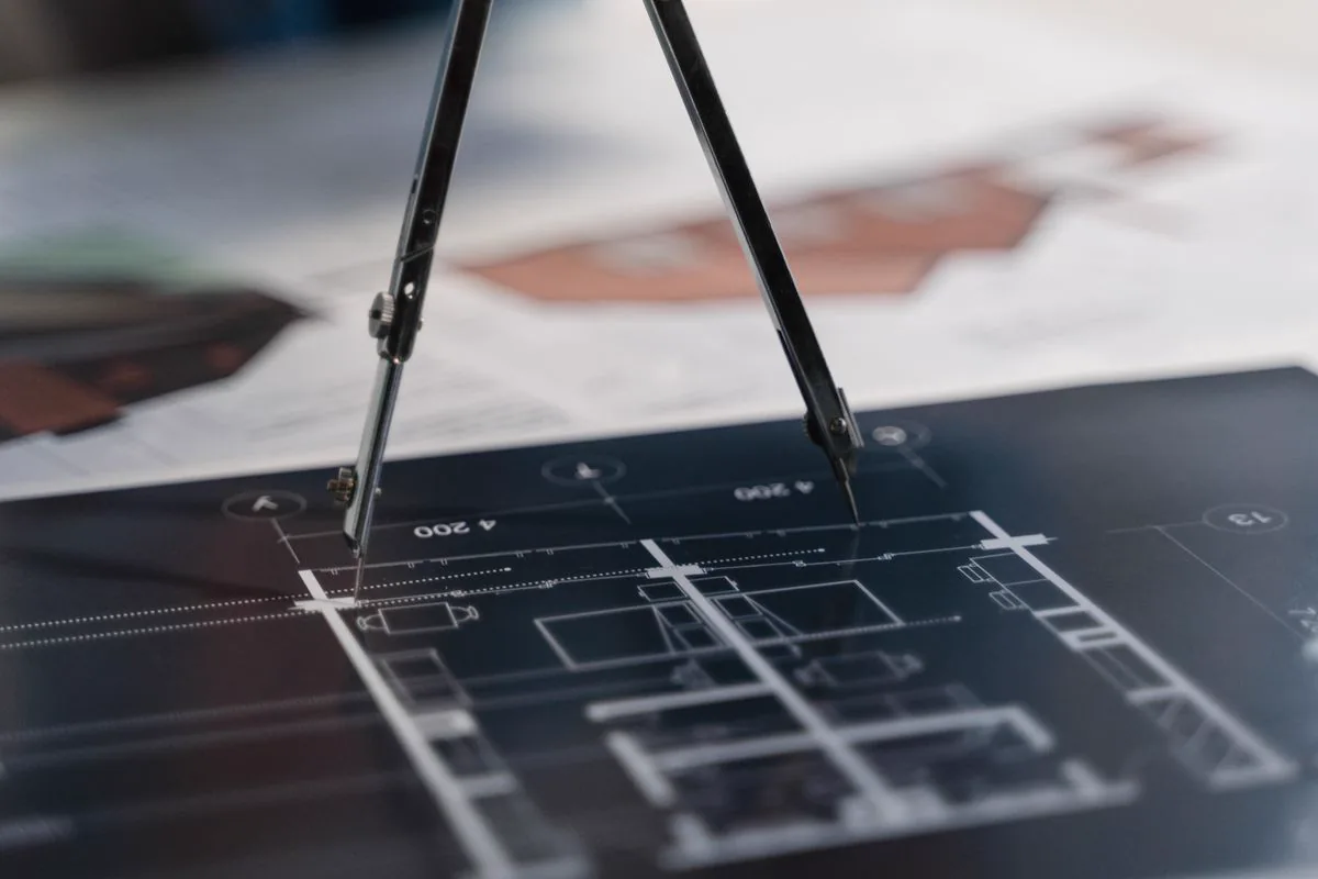 Compass and scale ruler resting on architectural blueprints